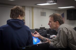Mr. Cortez helping a student with his computer science project.